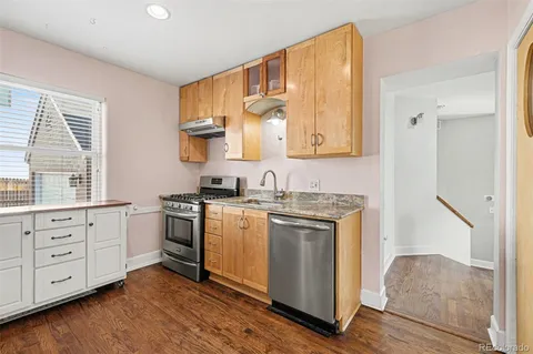 a kitchen with stainless steel appliances granite countertop a stove a sink and a refrigerator