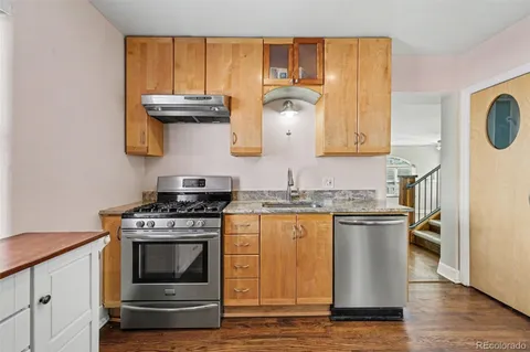 a kitchen with stainless steel appliances granite countertop a stove and a wooden cabinets