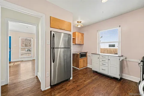 an empty room with wooden floor fireplace and windows