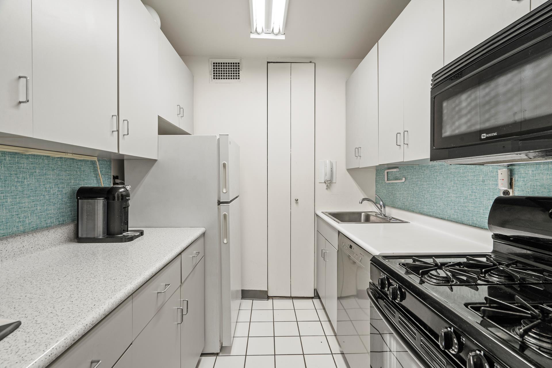 400 East 54th Street, Unit 14E Manhattan, NY 10022 - Photo 4 of 14 a kitchen with stainless steel appliances granite countertop a sink stove and refrigerator