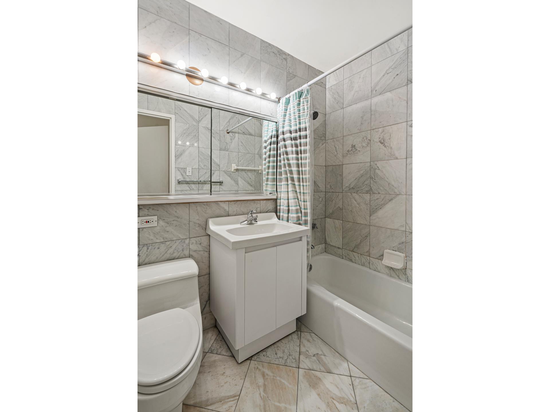 400 East 54th Street, Unit 14E Manhattan, NY 10022 - Photo 5 of 14 a bathroom with a sink a toilet and shower