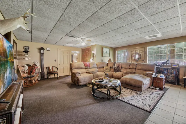 a living room with furniture a pool table and a ceiling fan