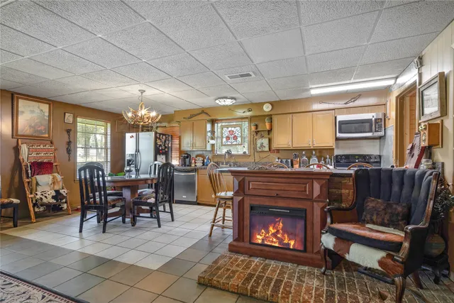 a dining room with furniture a chandelier and window
