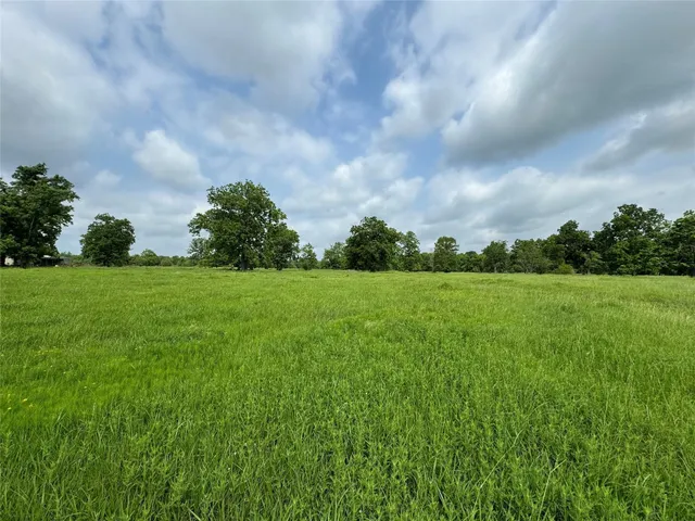 a view of a green field with wooden fence