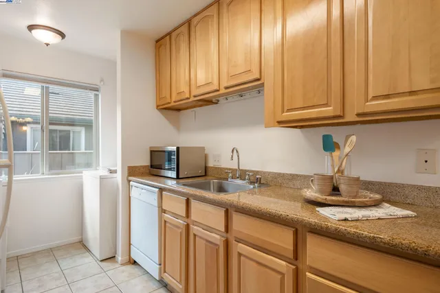 a kitchen with stainless steel appliances granite countertop a refrigerator sink and stove