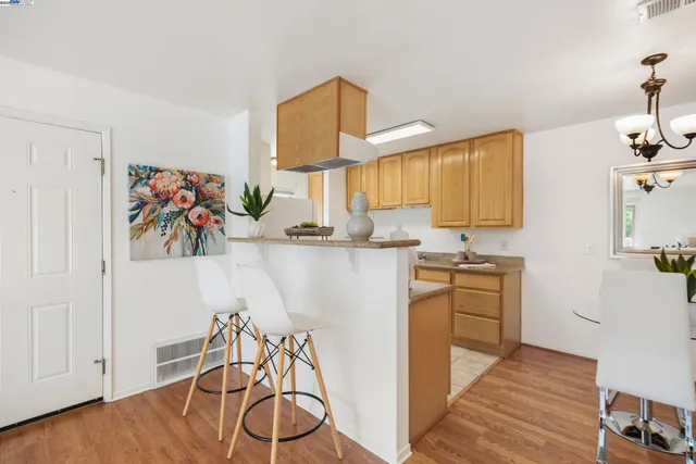a kitchen with stainless steel appliances granite countertop a sink a stove and a wooden floors