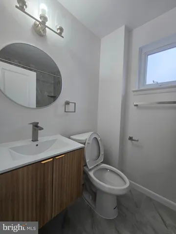 a bathroom with a toilet a sink and mirror