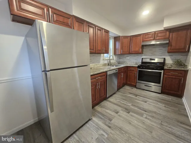 a kitchen with stainless steel appliances granite countertop a refrigerator stove a sink and dishwasher