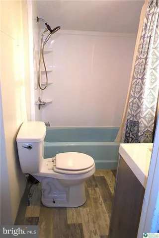 a bathroom with a granite countertop toilet and a sink