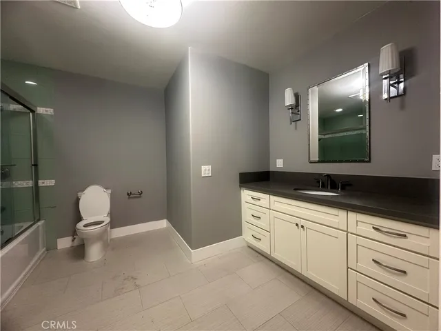 a spacious bathroom with a toilet sink and mirror