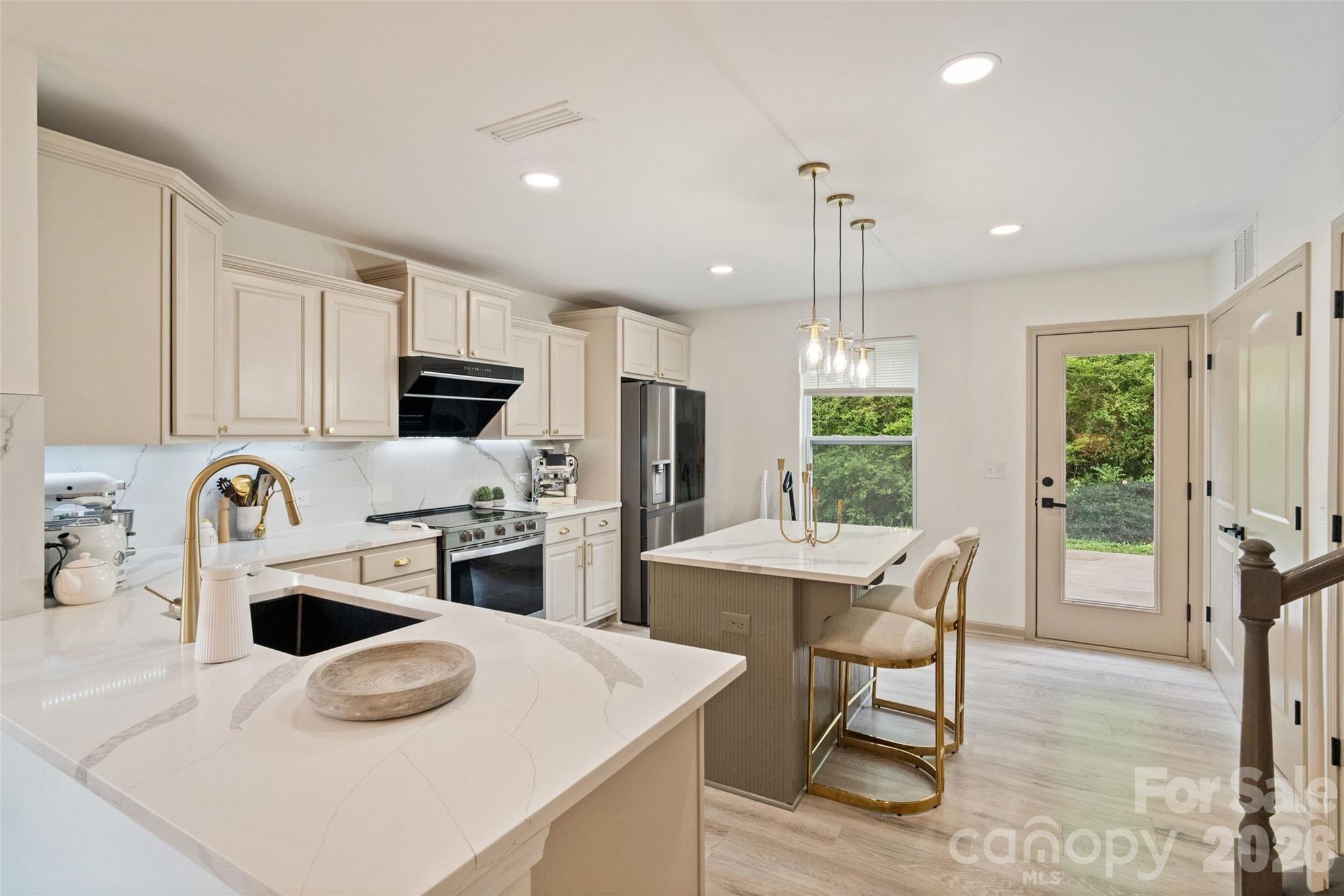 8726 Conrad Street Locust, NC 28097 - Photo 12 of 36 a kitchen with kitchen island a white stove top oven cabinets and a dining table