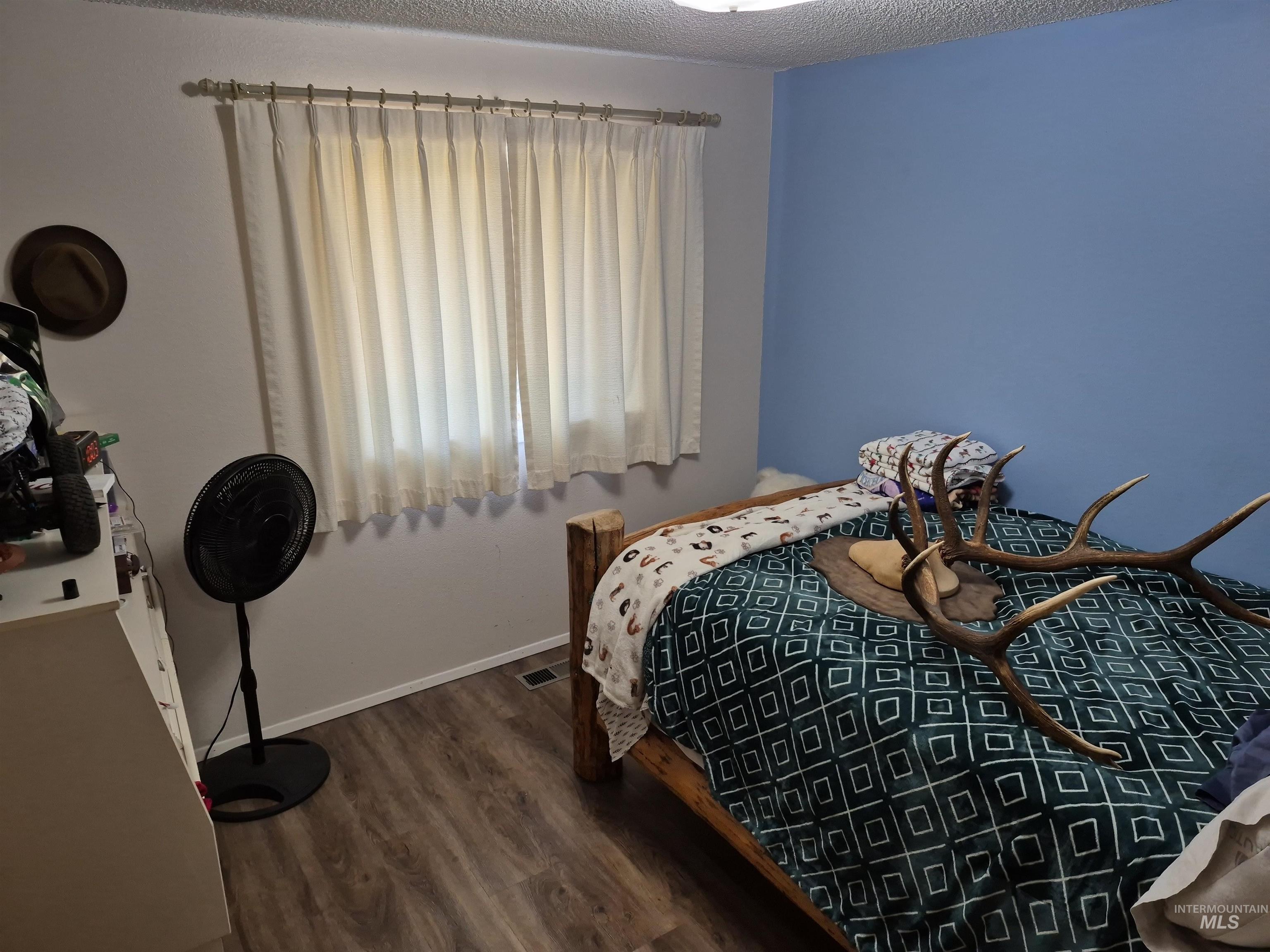 701 Wheeler Street Kendrick, ID 83537 - Photo 22 of 32 Bedroom with dark wood-style flooring and a textured ceiling