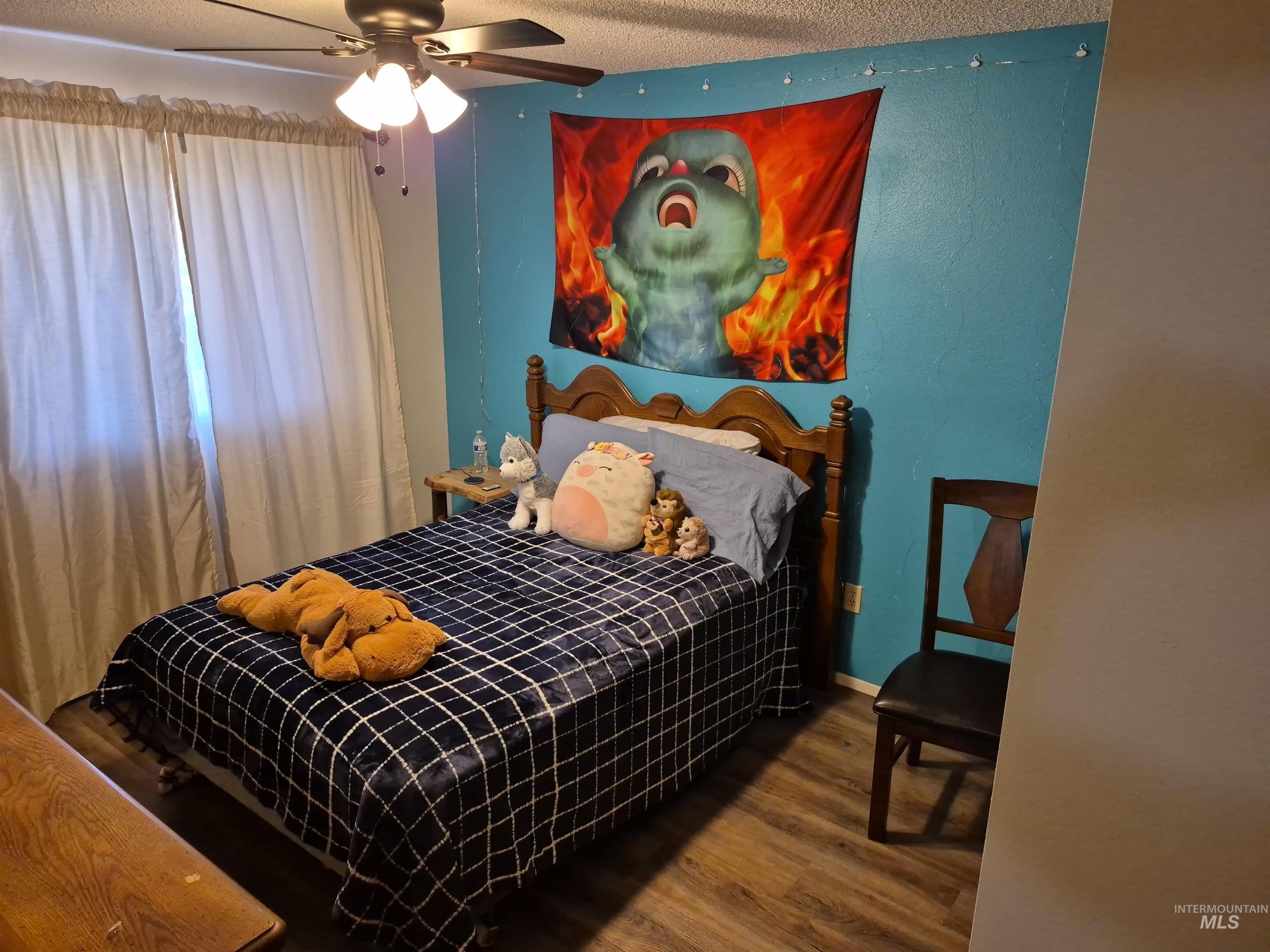 701 Wheeler Street Kendrick, ID 83537 - Photo 24 of 32 Bedroom featuring dark wood-type flooring, a textured ceiling, and ceiling fan
