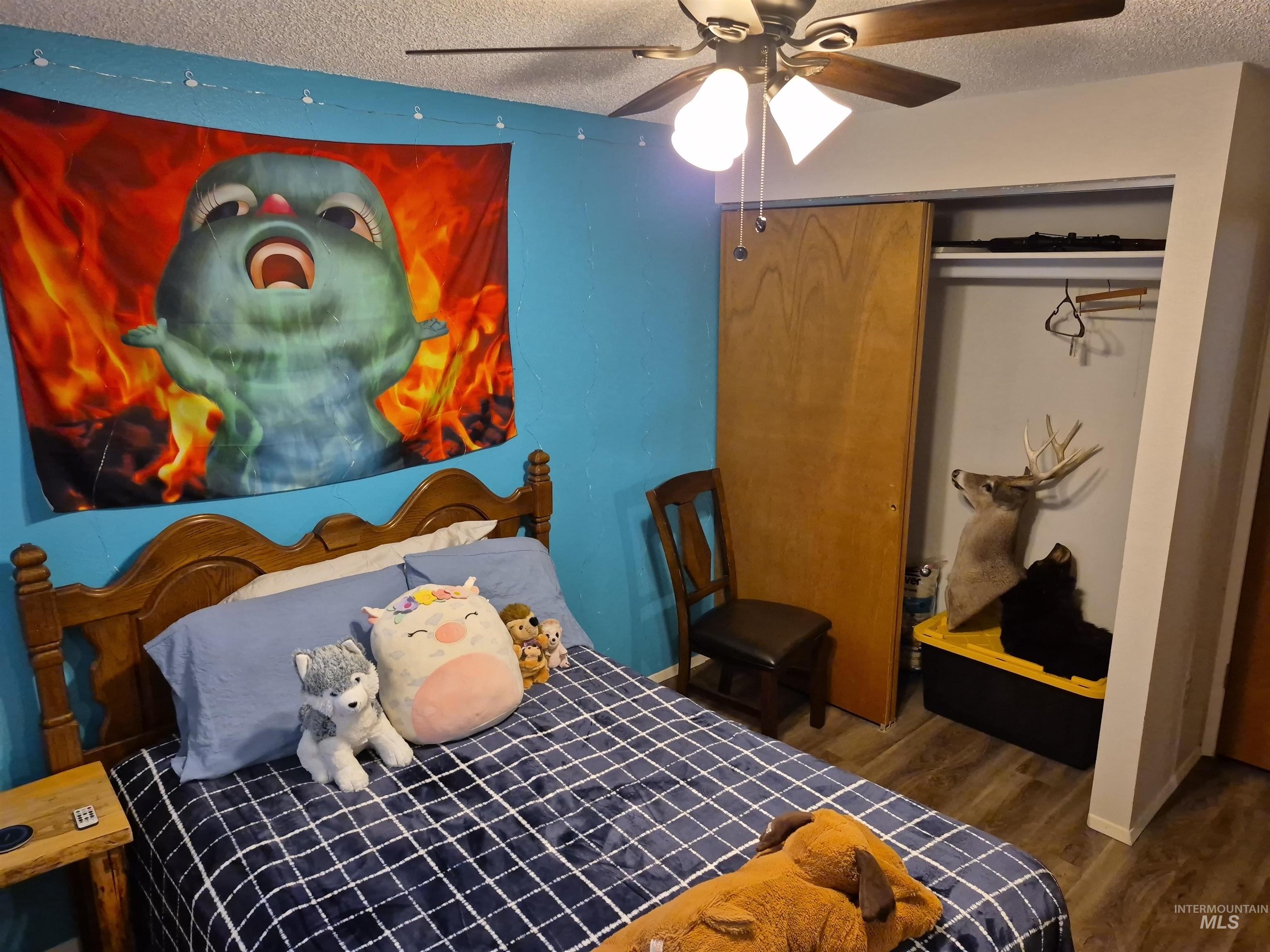 701 Wheeler Street Kendrick, ID 83537 - Photo 25 of 32 Bedroom featuring a textured ceiling, dark wood finished floors, a closet, and ceiling fan