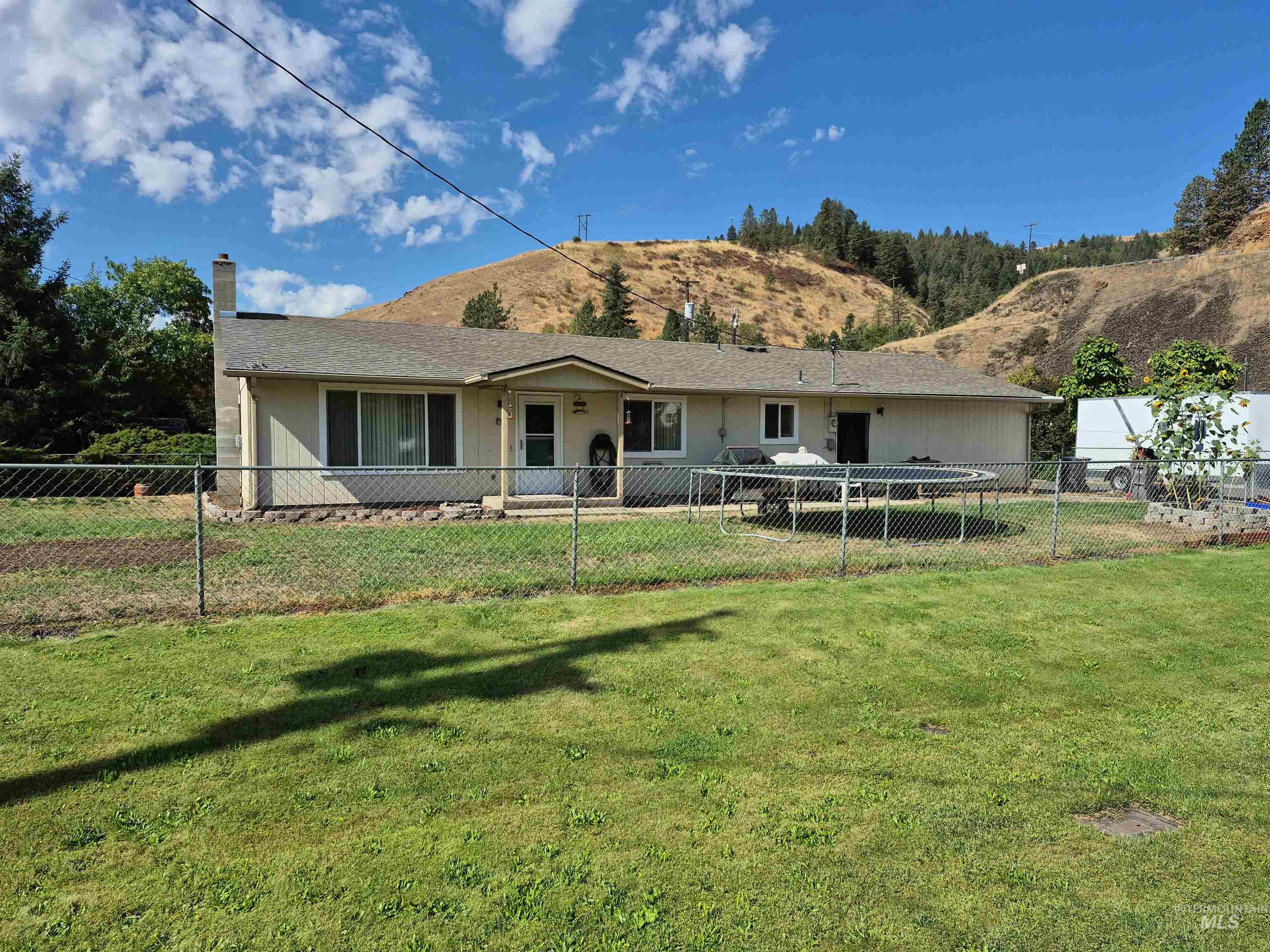 701 Wheeler Street Kendrick, ID 83537 - Photo 31 of 32 Back of house with a mountain view, a chimney, and a patio