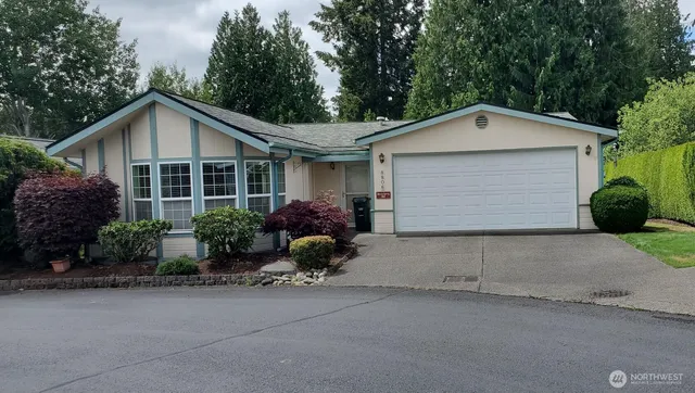 a view of a house with garage and plants