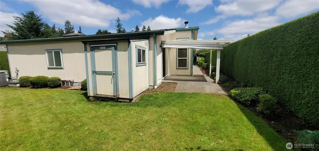 a view of a backyard with potted plants and wooden fence