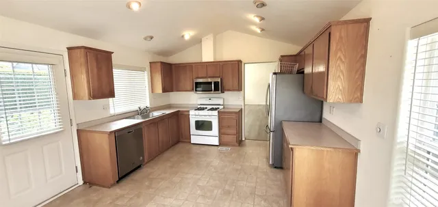 a kitchen with stainless steel appliances granite countertop a stove a sink and a refrigerator