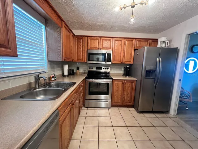 a kitchen with granite countertop a refrigerator and a sink