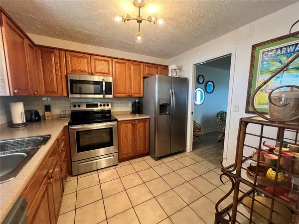 a kitchen with stainless steel appliances granite countertop a refrigerator and a stove top oven