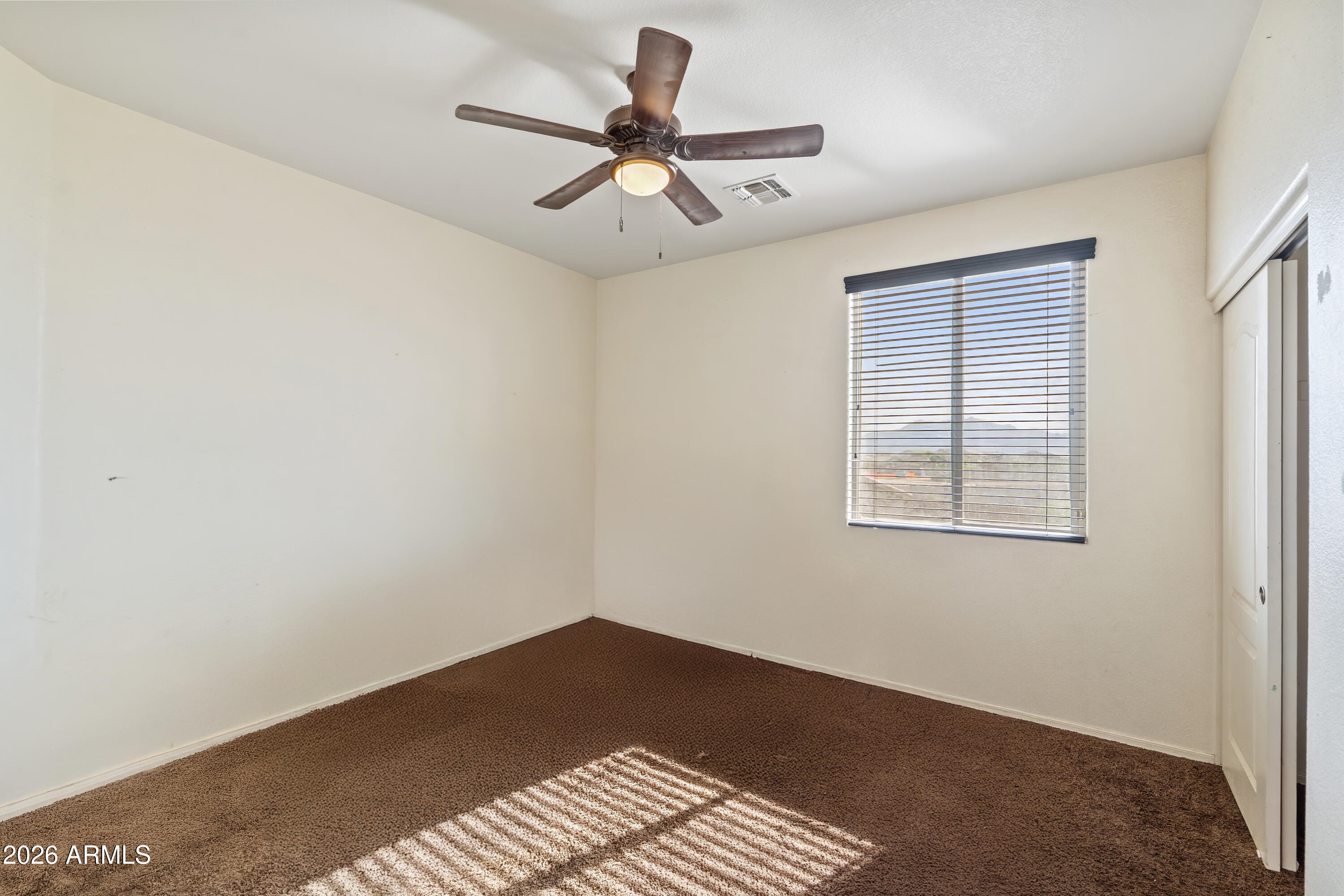 7634 West Apollo Road Laveen, AZ 85339 - Photo 26 of 34 a view of a room with a ceiling fan and wooden floor