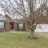 a front view of a house with yard and trees