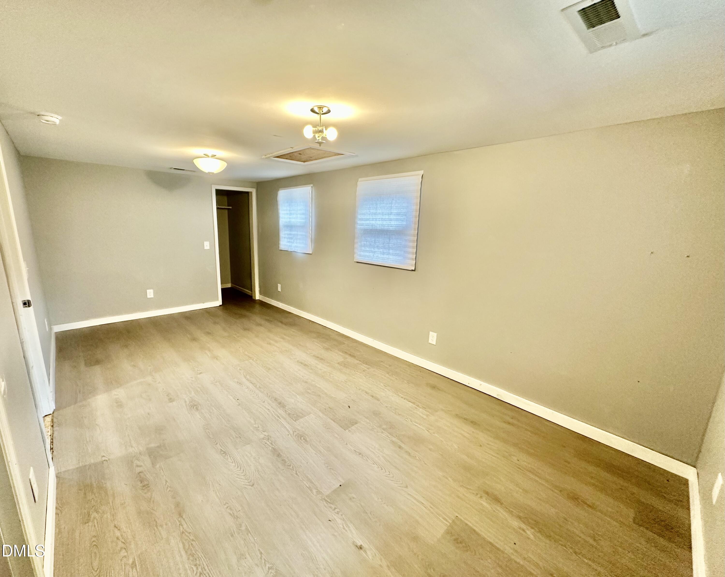 8205 Old Switchboard Road Snow Camp, NC 27349 - Photo 16 of 25 an empty room with wooden floor and chandelier