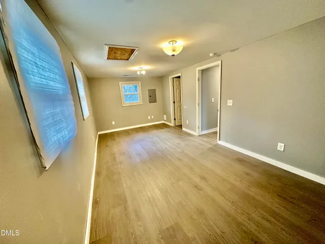 a view of an empty room with wooden floor