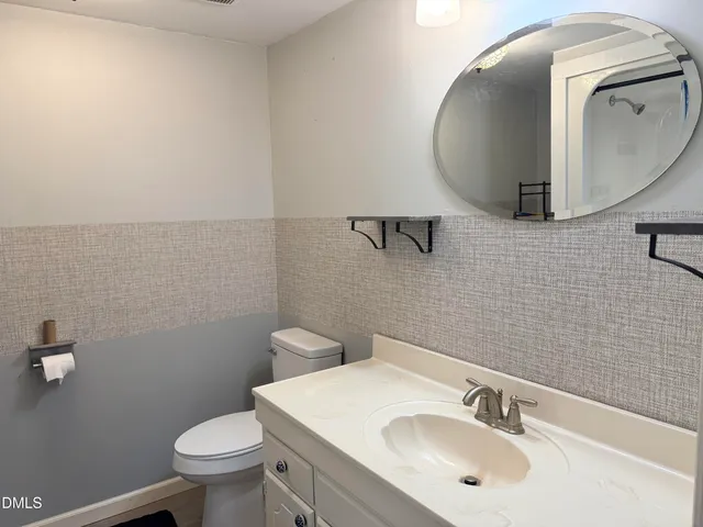 a bathroom with a sink mirror and toilet