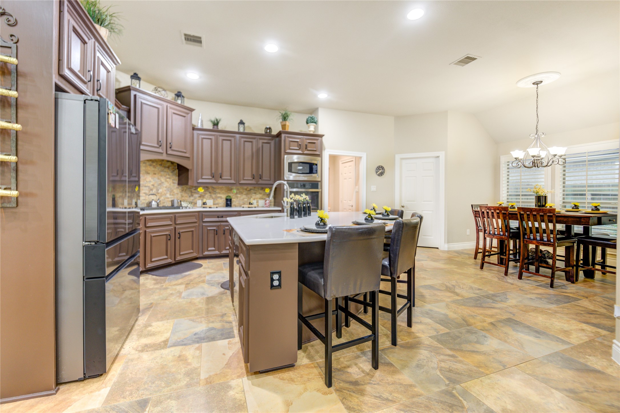 25831 Morgan Springs Spring, TX 77373 - Photo 14 of 49 a kitchen with kitchen island a dining table chairs and white cabinets
