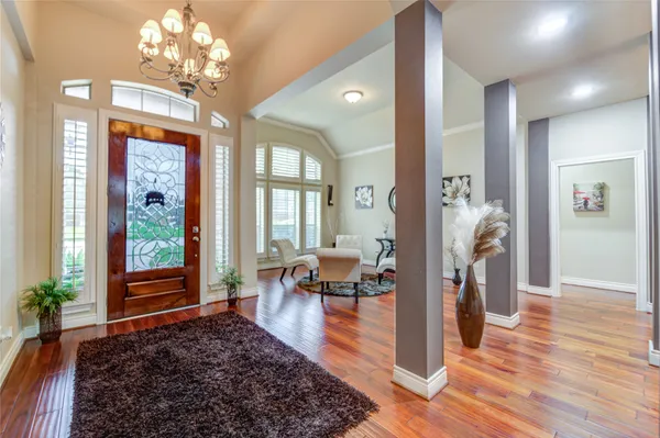 a view of a dining room with furniture a chandelier and wooden floor