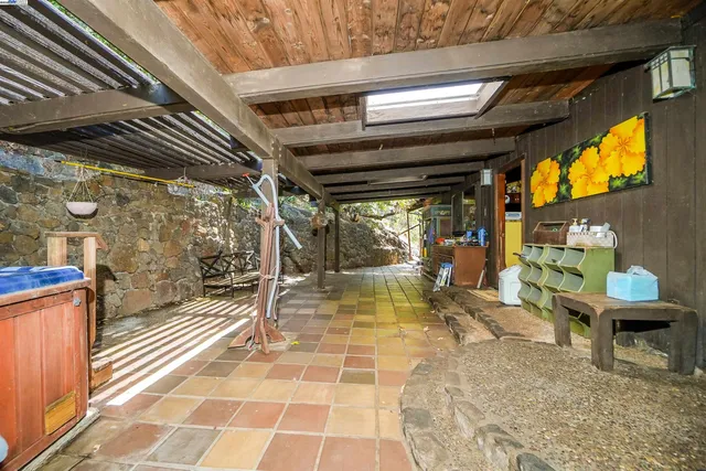 a view of a garage with wooden fence and large trees