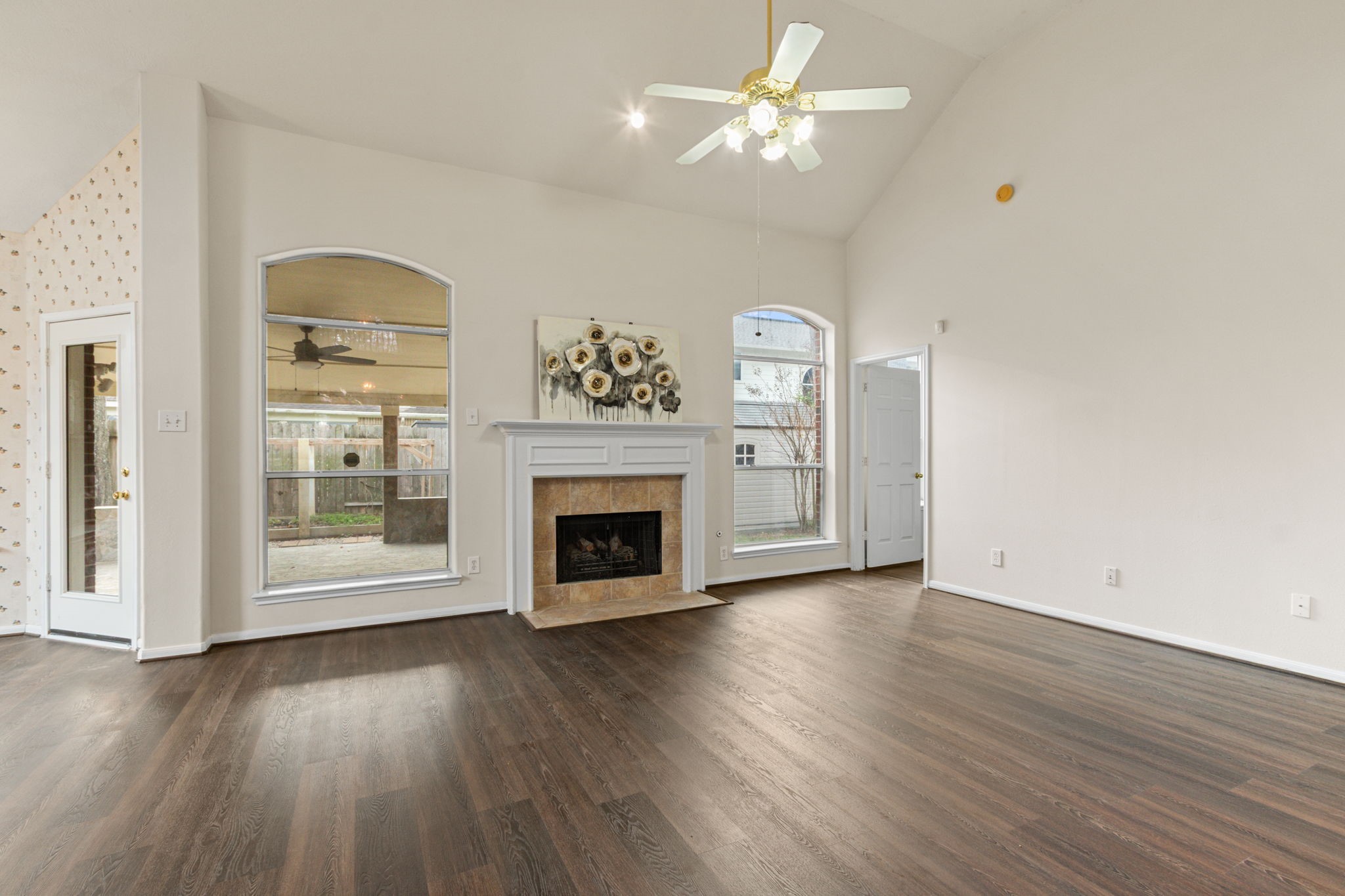 20907 Divellec Lane Spring, TX 77388 - Photo 11 of 50 an empty room with wooden floor fireplace and windows