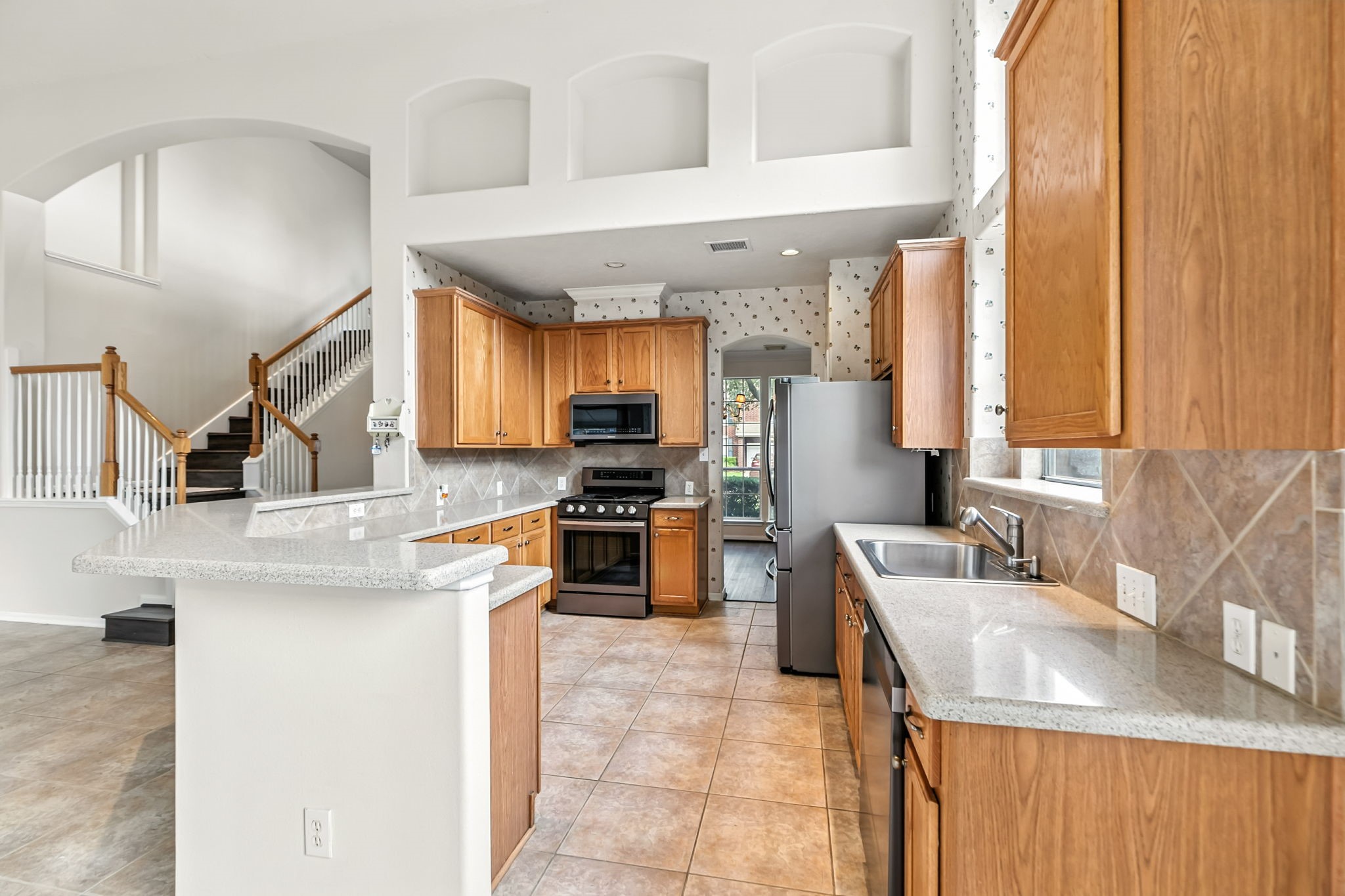 20907 Divellec Lane Spring, TX 77388 - Photo 15 of 46 a kitchen with stainless steel appliances kitchen island granite countertop a sink and a refrigerator
