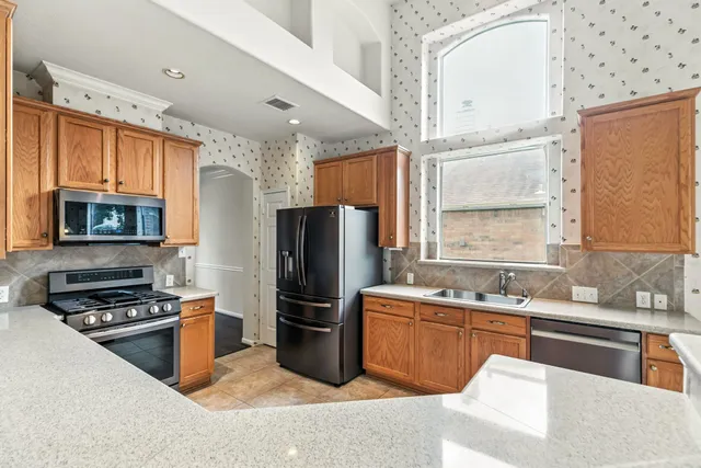 a kitchen with a sink a stove top oven and refrigerator