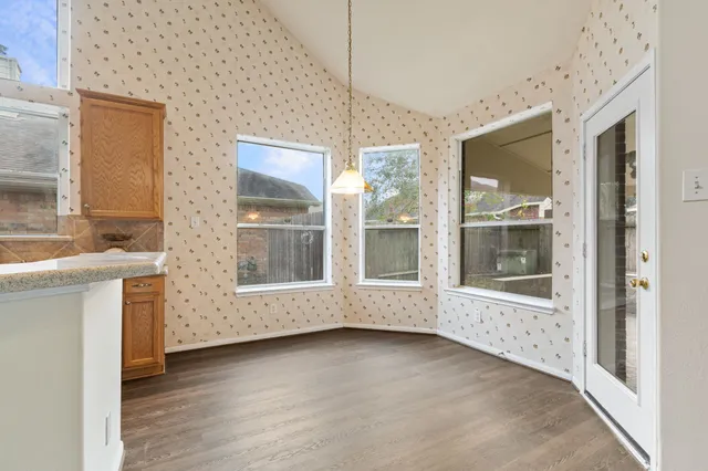 a view of empty room with wooden floor