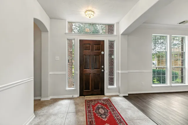 an entryway at an empty room with wooden floor and a window