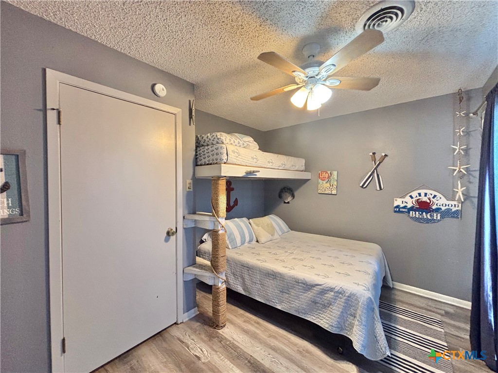 438 15th Street Port O'Connor, TX 77982 - Photo 16 of 26 a bedroom with a bed and a chandelier