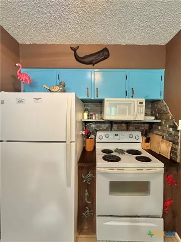 a white stove top oven sitting inside of a kitchen