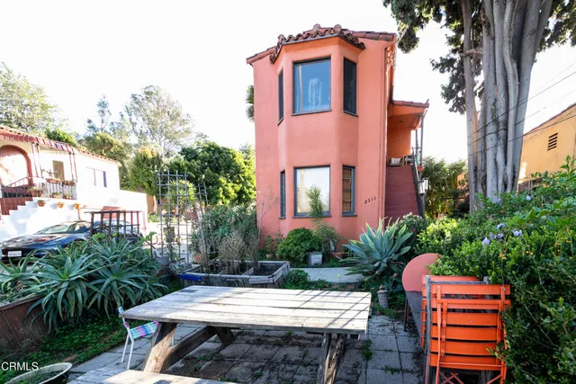 a view of a house with a chairs and table in a patio