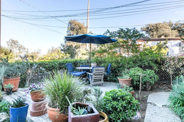 a view of a chair and table in backyard with plants