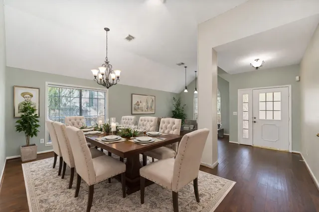 a view of a dining room with furniture wooden floor and chandelier