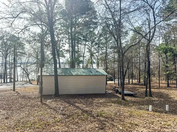 a backyard of a house with a large tree and wooden fence