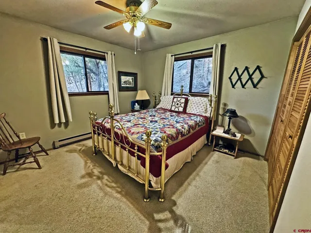 a bed sitting in a spacious bedroom next to a window