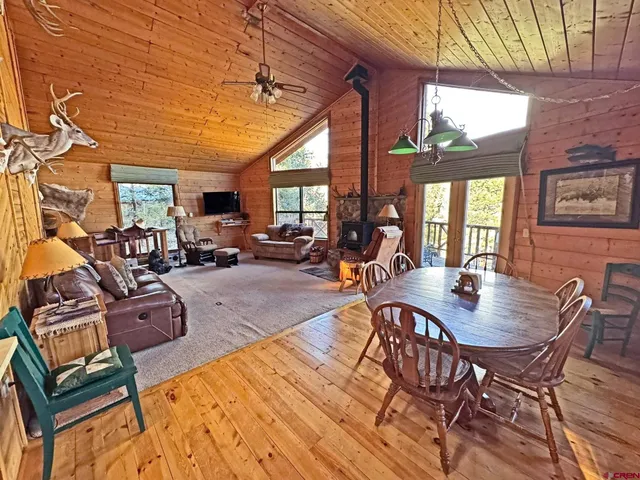 a view of a dining room with furniture a chandelier and wooden floor