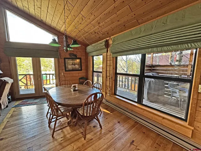 a view of a dining room with furniture large windows and wooden floor