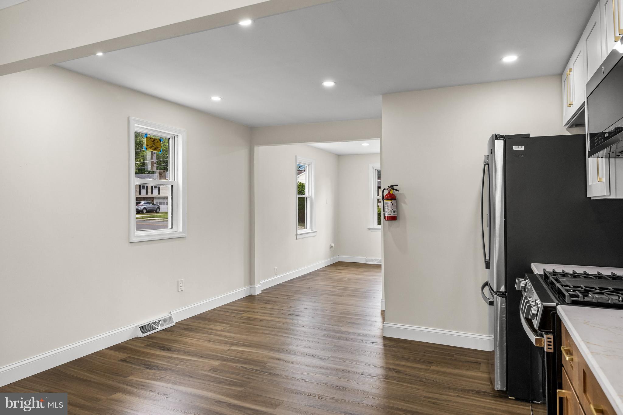 937 Clements Bridge Road Barrington, NJ 08007 - Photo 15 of 34 an empty room with wooden floor and a refrigerator