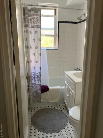 a bathroom with a sink a mirror a window and a shower