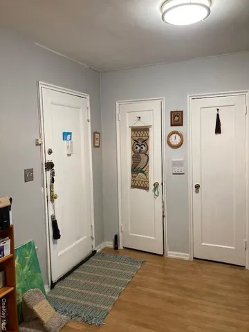 an empty room with window and hardwood floor