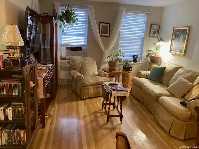 a living room with furniture a flat screen tv and a wooden floor